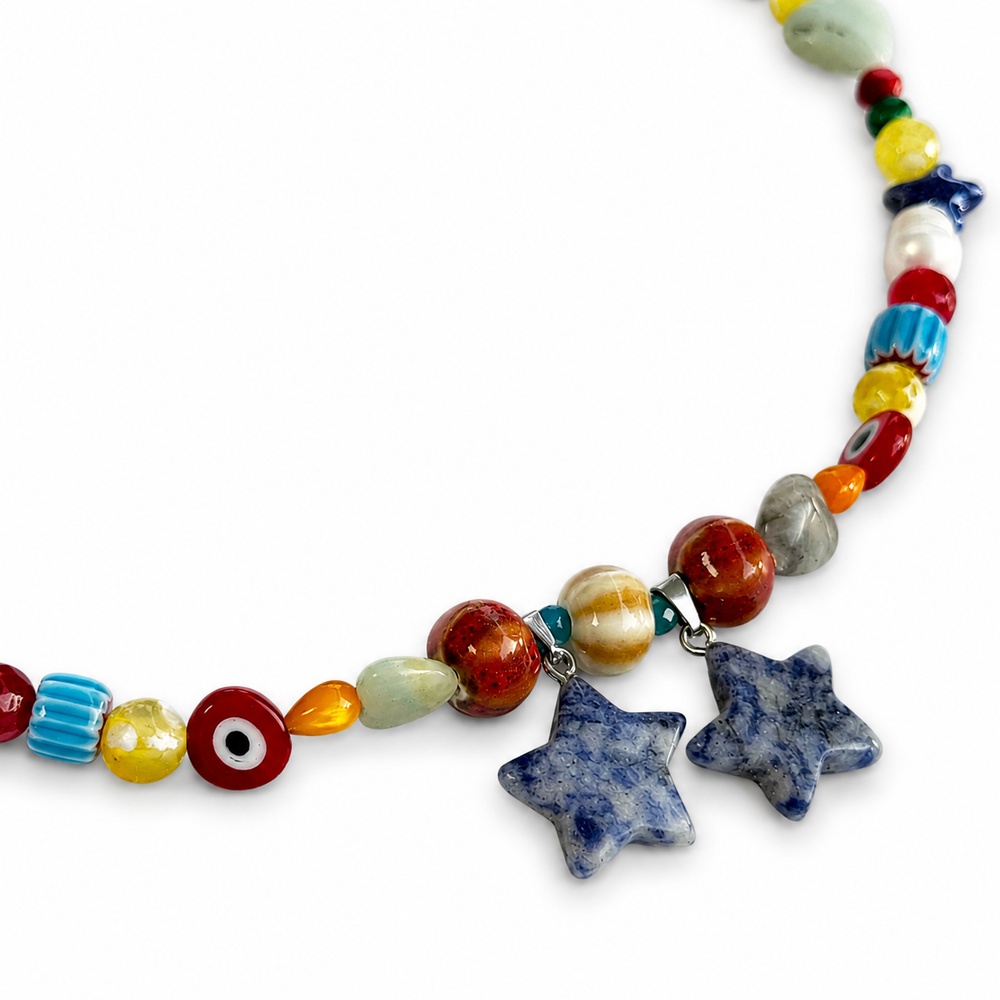 Detalle del collar con cuentas de colores, motivos de ojo, corazones verdes y estrellas azules jaspeadas