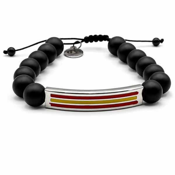 Pulsera negra con cuentas mate, cordón ajustable y placa central con los colores de la bandera de España