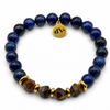 Pulsera de lapislázuli azul y ojo de tigre facetado con separadores dorados sobre fondo blanco